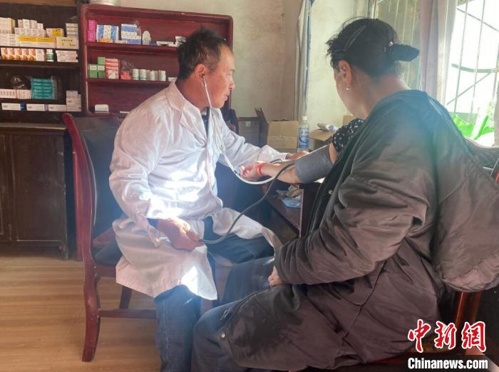 索木滾(左)為村民看病?！∪捞量h委宣傳部供圖