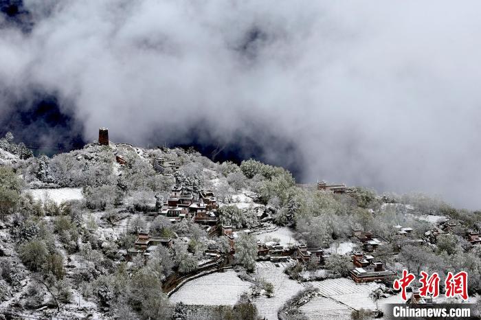 雪后的藏寨和碉樓構成美麗的雪景?！〗党鯘衫?攝