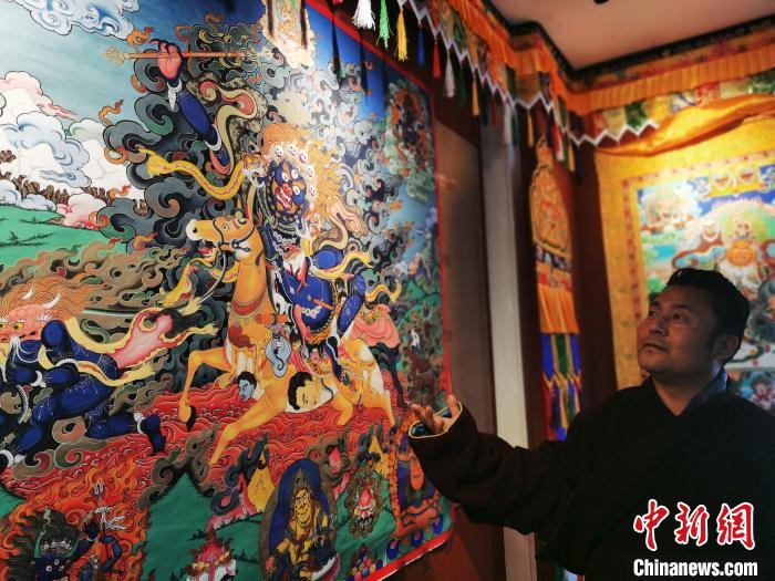 圖為久美尖措展示唐卡作品。　張?zhí)砀?攝