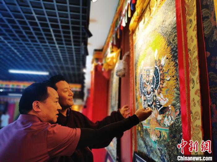 圖為久美尖措展示唐卡作品。　張?zhí)砀?攝