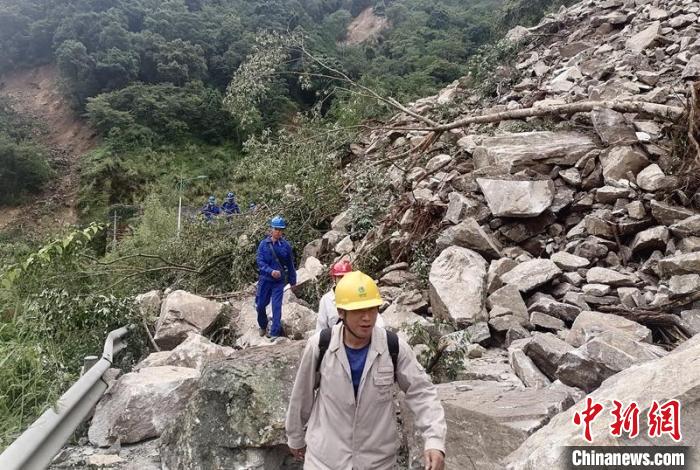 電力搶險(xiǎn)人員徒步通過(guò)垮塌路段?！∷拇娏﹫D