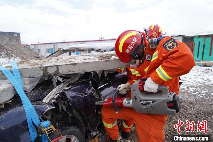 圖為地震實戰(zhàn)拉動現(xiàn)場，參演人員進行車輛破拆?！∮駱湎拦﹫D