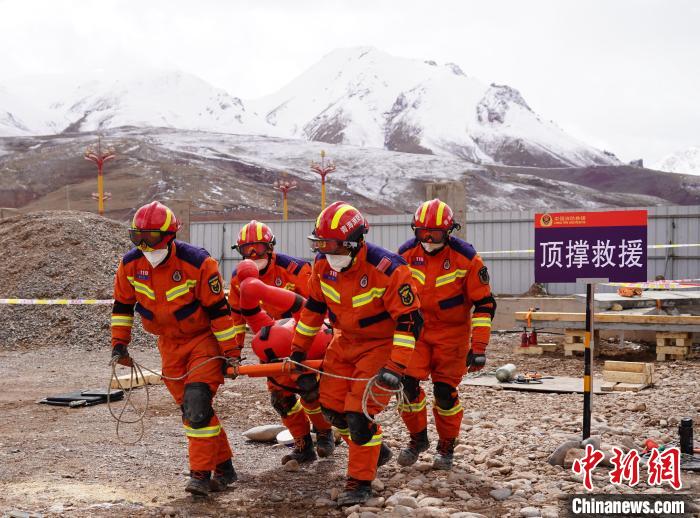 圖為地震實戰(zhàn)拉動現(xiàn)場，參演人員正在轉移受傷人員?！∮駱湎拦﹫D