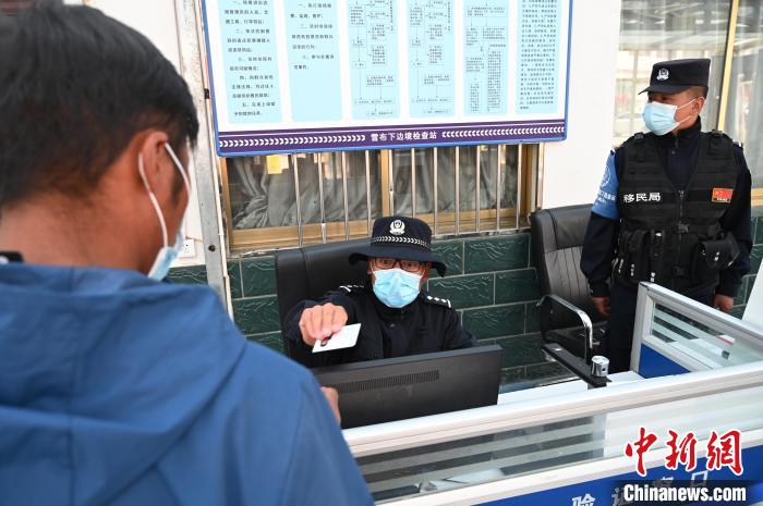 圖為移民管理警察登記完身份信息后將證件歸還給行人。　趙朗 攝