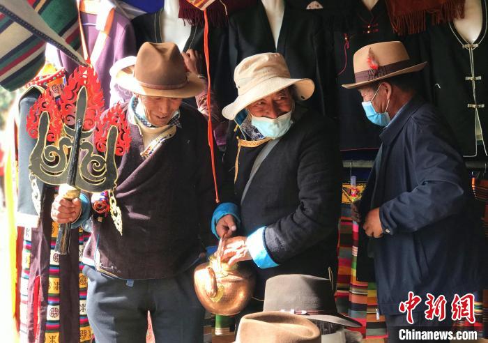 圖為三位藏族老人在集市上聊天交談?！∪轿木?攝
