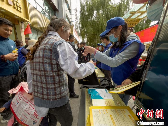圖為志愿者為市民發(fā)放網(wǎng)絡(luò)安全宣傳手冊(cè)?！≈x牧 攝