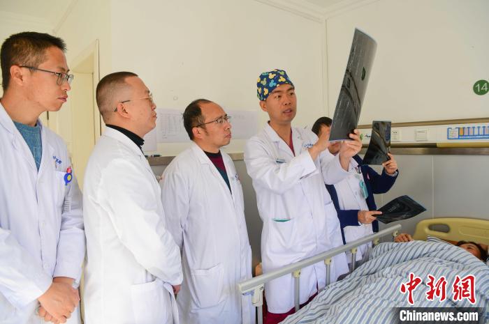 圖為何蔚副主任醫(yī)師(站右二)及團隊討論患者病情?！∝暩聛硭?攝