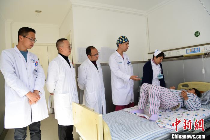 圖為何蔚副主任醫(yī)師(站右二)及團隊術(shù)后指導患者進行腰背肌鍛煉?！∝暩聛硭?攝