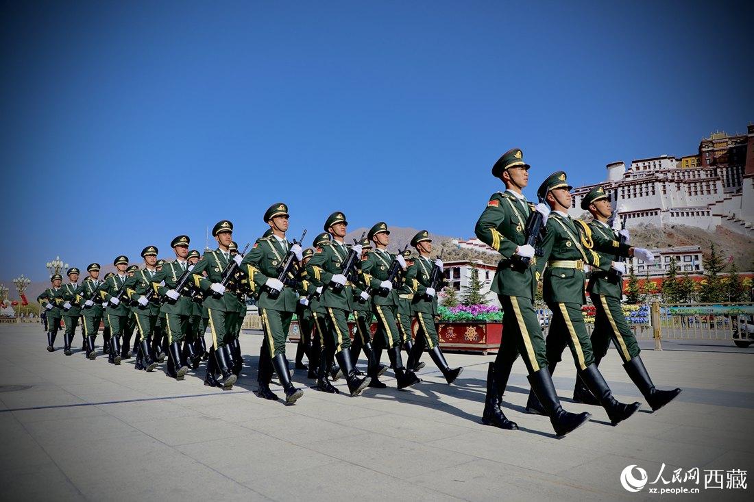 國旗護(hù)衛(wèi)隊(duì)隊(duì)員緊握鋼槍，踏著威武雄壯的步伐，走向國旗臺。人民網(wǎng) 次仁羅布攝