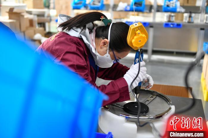 圖為工人正在組裝炊具?！∝暩聛硭?攝