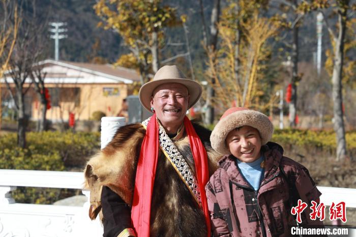 圖為林芝市巴宜區(qū)布久鄉(xiāng)仲果村村民桑杰與孫子一起參加藏歷新年活動?！埩?攝