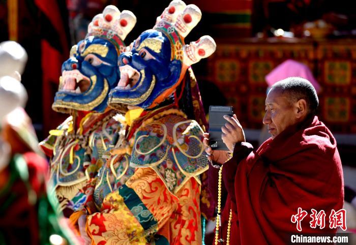 2月19日，正在拍攝跳神活動(dòng)的僧人?！±盍?攝