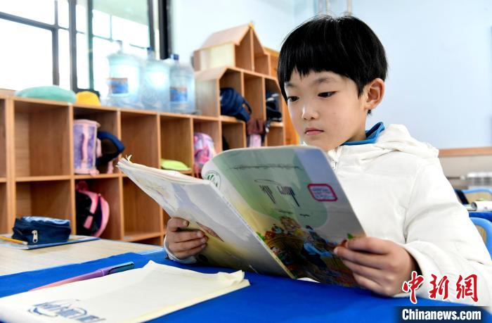 3月14日，西藏拉薩市第一小學(xué)一年級(jí)六班學(xué)生丁增樂吉在閱讀藏語課本。　李林 攝