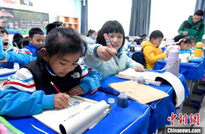 3月14日，西藏拉薩市第一小學(xué)一年級(jí)六班學(xué)生白瑪朗珍(圖左)在藏語文課上書寫藏文?！±盍?攝