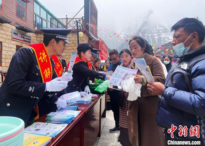 圖為山南玉麥邊境派出所民警為轄區(qū)群眾發(fā)放法律知識(shí)宣傳單?！＄婗?　攝