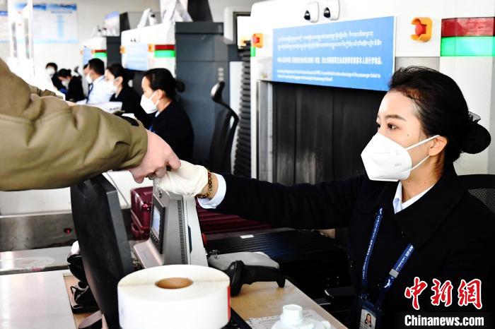 圖為機場工作人員為旅客辦理行李托運?！≈芎?攝