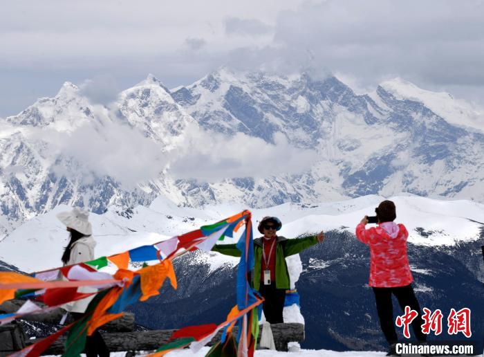 圖為5月14日，西藏林芝色季拉山觀景臺(tái)，游客與南迦巴瓦峰合影。　李林 攝