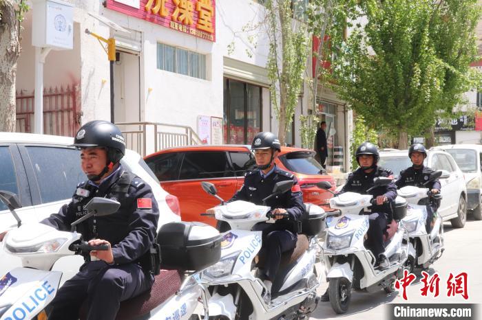 民警騎著電瓶車在轄區(qū)巡邏走訪。　黃創(chuàng)偉 攝