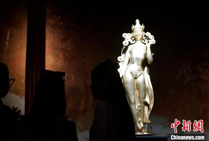 圖為觀眾正在欣賞展覽中的雕塑作品《八萬四千年》?！±盍?攝