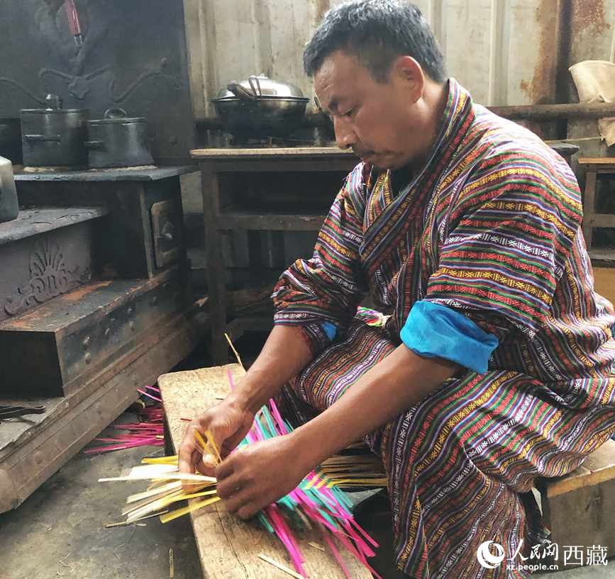 門巴族漢子愛明正在編織藤竹品。