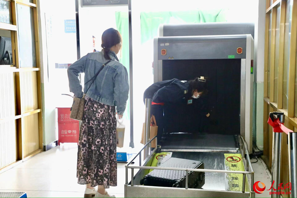 車站工作人員幫旅客提取行李。人民網(wǎng)記者 次仁羅布攝