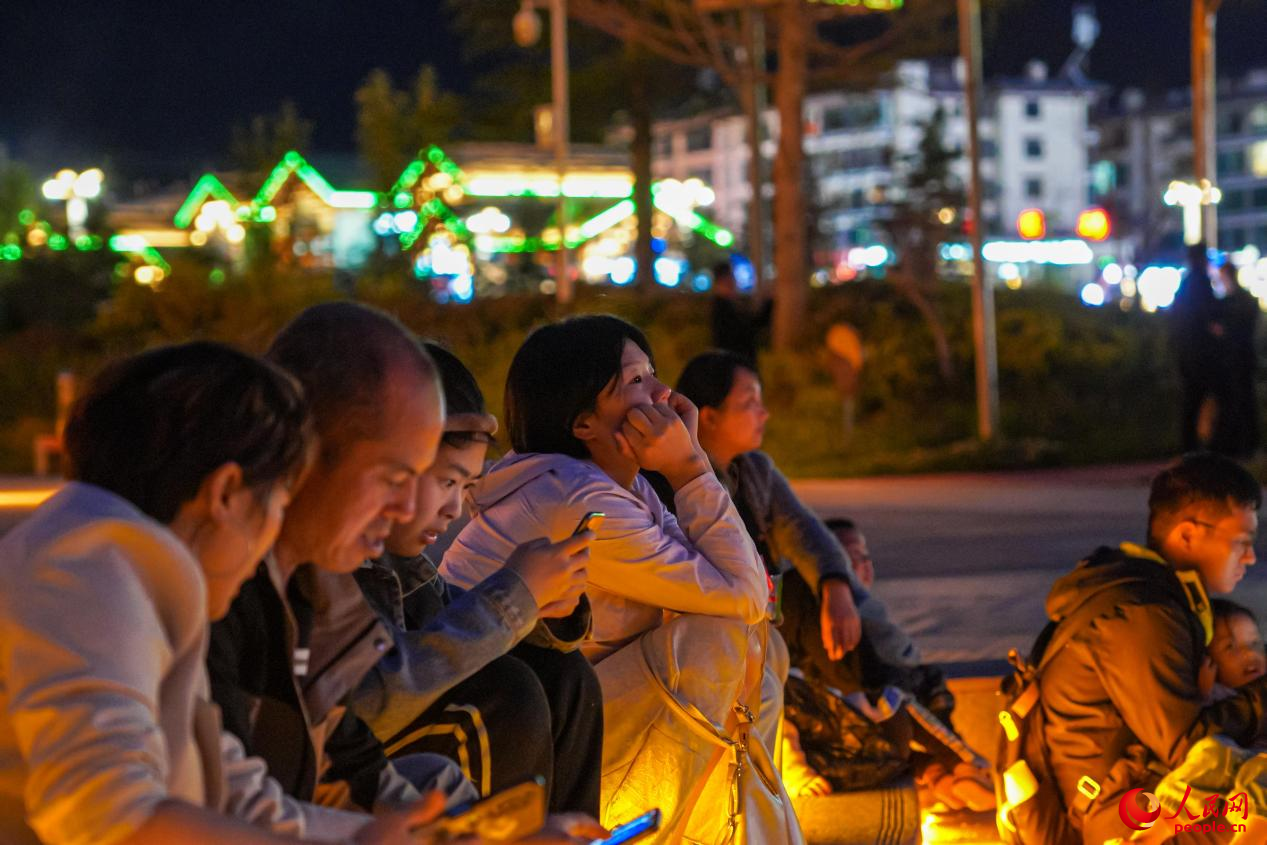 市民坐在西藏林芝市民族團(tuán)結(jié)廣場(chǎng)臺(tái)階上欣賞音樂噴泉。人民網(wǎng)記者 趙晨攝