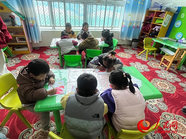 拉多村一所現(xiàn)代化幼兒園小班孩子們正在繪畫(huà)。張敏穎 攝